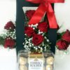 Red Roses arranges in a box with a red bow with Chocolates on the side