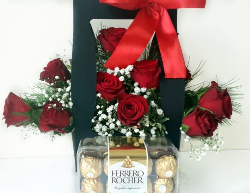 Red Roses arranges in a box with a red bow with Chocolates on the side