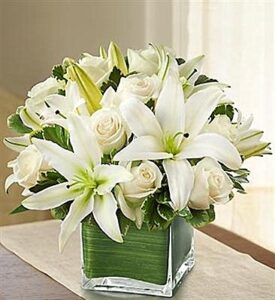 roses and lilies arranged in square flower vase