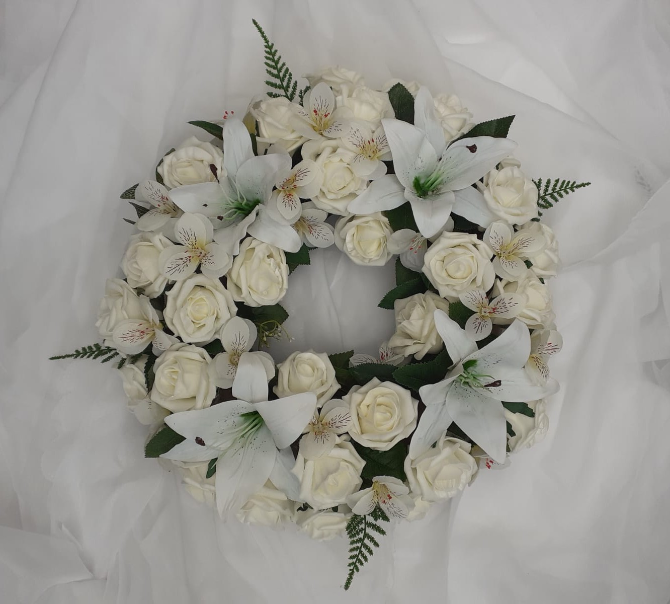 White artificial funeral wreath with roses and lilies